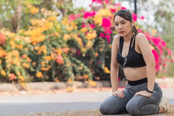 Güzel Asyalı kadın koşu sırasında kas hasarlarını azaltmak için kaslarını çalıştırmak için vücudunu ısıtıyor. Güzel Asyalı kadın koşuya hazırlanmak için kaslarını esnetiyor. .