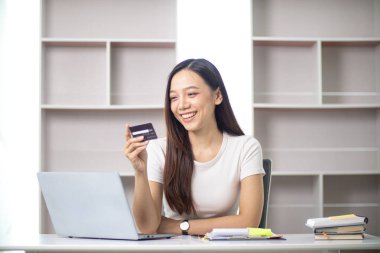 Asyalı iş kadınının portresi ofis malzemelerini sipariş etmek için kredi kartı kullanıyor İçişleri Bakanlığını KOBİ işine hazırlamak için ve kredi kartıyla ürünleri satışa çıkarmak için kullanıyor. Boşluğu kopyala