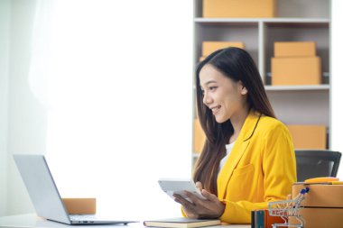 Güzel Asyalı iş kadını evini ofis ya da İçişleri Bakanlığı olarak kullanarak başlangıç maliyetlerinden tasarruf ederek KOBİ işine başlıyor. Portre KOBİ işine başladı İçişleri Bakanlığı 'ndan Asyalı iş kadını