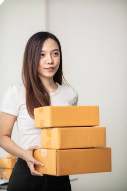 KOBİ işini İçişleri Bakanlığı 'nı kullanarak başlatan ve paketleri tek başına hazırlayan güzel Asyalı iş kadını, müşterilere nakliye yoluyla teslimat için hazırlanmak üzere birçok paket taşıyor.
