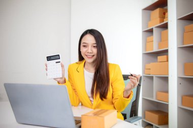 Güzel Asyalı iş kadını evini ofis ya da İçişleri Bakanlığı olarak kullanarak başlangıç maliyetlerinden tasarruf ederek KOBİ işine başlıyor. Portre KOBİ işine başladı İçişleri Bakanlığı 'ndan Asyalı iş kadını