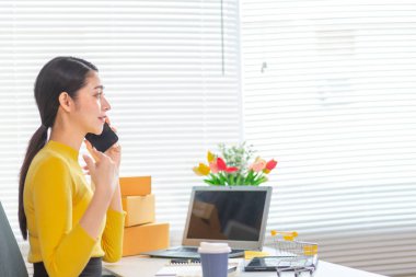 İş kadını, müşterilerden sipariş almak için cep telefonu uygulaması üzerinden ev ofisi kurar ve müşterilerle iletişime geçmek ve siparişleri göndermeden önce onaylamak için cep telefonunu kullanır. Boşluğu kopyala