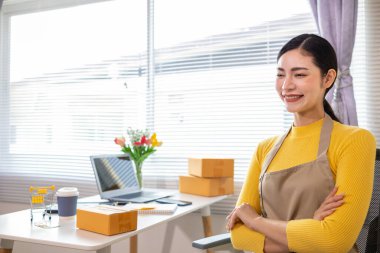 Asyalı işkadını, çevrimiçi alışveriş başvurusundan gelen siparişe göre ürünleri doğru şekilde teslim etmek için stok ve siparişleri kontrol ediyor. Asyalı iş kadını çevrimiçi alışveriş işine yatırım yapmaktan mutluluk duyar