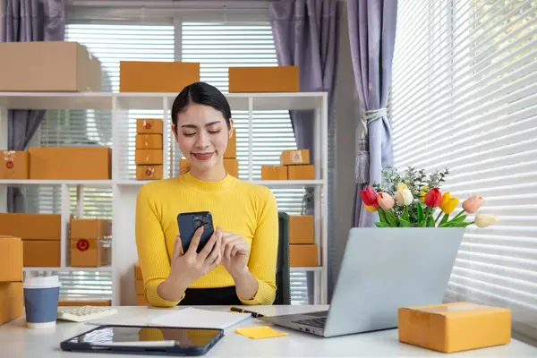 İş kadını, müşterilerden sipariş almak için cep telefonu uygulaması üzerinden ev ofisi kurar ve müşterilerle iletişime geçmek ve siparişleri göndermeden önce onaylamak için cep telefonunu kullanır. Boşluğu kopyala