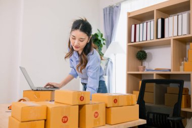 Asyalı bir kadın, evini İçişleri Bakanlığı olarak kullanarak küçük bir KOBİ işine başlıyor ve müşterilere siparişlere göre yeterli ürün olup olmadığını kontrol etmek için envanteri kontrol ediyor. Küçük KOBİ İş Başlangıcı
