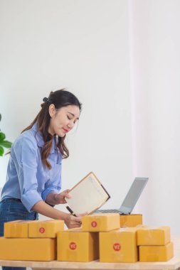 Asyalı bir kadın, evini İçişleri Bakanlığı olarak kullanarak küçük bir KOBİ işine başlıyor ve müşterilere siparişlere göre yeterli ürün olup olmadığını kontrol etmek için envanteri kontrol ediyor. Küçük KOBİ İş Başlangıcı
