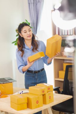 Asyalı bir kadın, evini İçişleri Bakanlığı olarak kullanarak küçük bir KOBİ işine başlıyor ve müşterilere siparişlere göre yeterli ürün olup olmadığını kontrol etmek için envanteri kontrol ediyor. Küçük KOBİ İş Başlangıcı