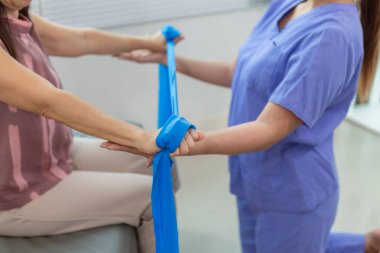 Doktor, yaşlılarda fiziksel tedaviye yardım etmek için elastik bant kullanır. Yaralandıktan sonra kaslarının işlevini yerine getirir. Vücudun çeşitli yerlerindeki yaraları tedavi ettikten sonra terapi hala önemlidir..