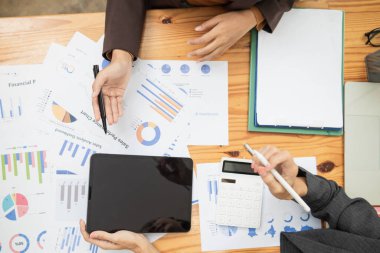 Müşterek iş yatırımlarının yıllık performansı ile ilgili belgelerle konferans odasındaki masanın üst görüntüsü işadamları tarafından analiz ediliyor ve yatırımların devamı hakkında tartışılıyor..