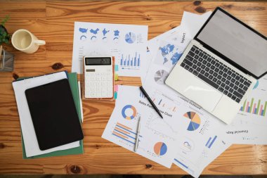 Yıllık mali açıklamalar ve şirketin kâr istatistiklerini derleyen belgeler de dahil olmak üzere birçok belge masanın üzerinde hazır bulunuyor. Ofisteki masanın üzerine bir sürü belge konur..