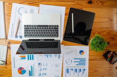 Yıllık mali açıklamalar ve şirketin kâr istatistiklerini derleyen belgeler de dahil olmak üzere birçok belge masanın üzerinde hazır bulunuyor. Ofisteki masanın üzerine bir sürü belge konur..