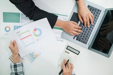 Müşterek iş yatırımlarının yıllık performansı ile ilgili belgelerle konferans odasındaki masanın üst görüntüsü işadamları tarafından analiz ediliyor ve yatırımların devamı hakkında tartışılıyor..