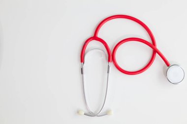 Ofisteki doktor masasındaki stetoskop hasta sağlık kontrolüne geldiğinde kalp atışlarını ölçmek için hazırdır. Stethoscope, Top View 'daki beyaz masanın üzerine metin için Kopyalama Boşluğu ile yerleştirilmiştir.