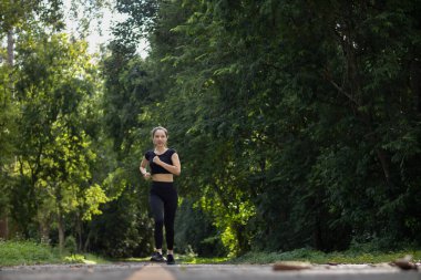 Sokakta koşan Asyalı kadın koşucunun portresi çünkü koşmak sağlık için iyi bir egzersizdir. Güzel Asyalı bayan koşucu, iyi bir sağlık egzersizi için sabah sokakta tek başına koşuyor..