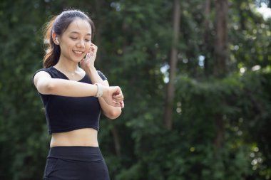 Bileğindeki akıllı saate bakan bir koşucunun portresi kalp atışlarını ve koşu mesafesini kontrol ediyor. Koşucu dikkat ediyor. Akıllı saati bileğinde. Nabzını ve koşu mesafesini kontrol ediyor..