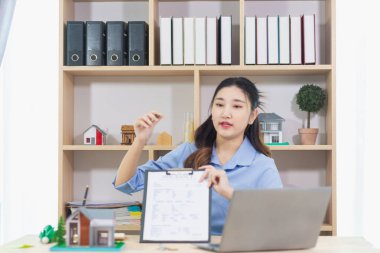 Emlakçılar müşteri bilgilerini kontrol ediyor ve emlak satışı için kontrat hazırlıyorlar. Gayrimenkul işlemlerinin yasal olarak tamamlanması için emlak sözleşmesi imzalanmaya hazır..