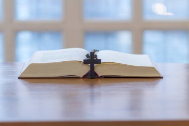 İncil, Tanrı 'ya dua etmek ve kendisini ve ailesini koruması için Tanrı' ya dua etmek amacıyla İncil 'i anlamak üzere masaya konmuştu. İncil öğrenme ve Tanrı 'ya inanç kavramı.