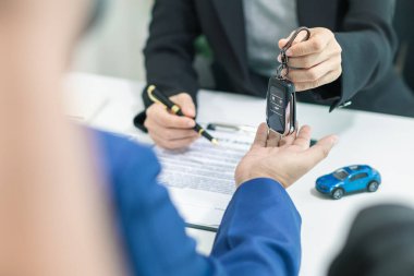 Alıcı, satış sözleşmesini tamamladıktan ve satıcıya ödeme yaptıktan sonra araba satıcısından araba anahtarlarını alıyor. Satıcı, satış sözleşmesini tamamladıktan sonra arabanın anahtarlarını ofisteki müşteriye verir..