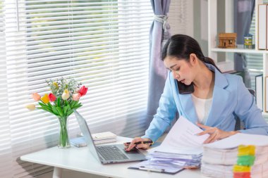 İş kadını, masasındaki çok sayıda belgenin hesaplarını kontrol etmek ve iş planını analiz etmek için belge arayışında olduğunu vurguladı. İş kadını çok sayıda belgenin altını çizdi