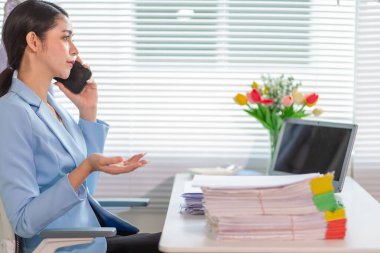 İş kadını, masasındaki çok sayıda belgenin hesaplarını kontrol etmek ve iş planını analiz etmek için belge arayışında olduğunu vurguladı. İş kadını çok sayıda belgenin altını çizdi