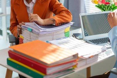 İki stresli iş kadını, hesaplarını kontrol etmek ve masalarındaki çok sayıdaki belgelerden iş planlarını analiz etmek için belge arıyorlar. Stresli iş kadınları çok sayıda belge üzerinde
