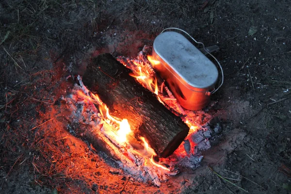 燃える丸太とキャンプ釜で森の中のキャンプファイヤー 森の中の観光 キャンプファイアの背景 — ストック写真