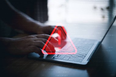 Üçgen uyarı işareti, kodlama, şifreleme, hacker, suç, virüs içeren dizüstü bilgisayar kullanan bir bilgisayar korsanı veya programcı. Kırmızı uyarı işareti olan bilgisayar.