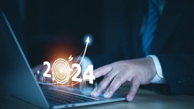 2024 iş hedefi teknoloji ve yatırım borsası ticaret kavramını finanse etmek. Sanal grafik simgesi tutan işadamı ön x veya kripto para birimi ticaret grafiği finansal verilerini analiz ediyor.