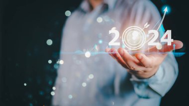 2024 iş hedefi teknoloji ve yatırım borsası ticaret kavramını finanse etmek. Sanal grafik simgesi tutan işadamı ön x veya kripto para birimi ticaret grafiği finansal verilerini analiz ediyor.