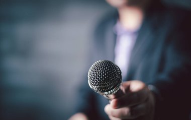 İş adamı takım elbiseli bir adam mikrofon tutuyor iş görüşmesi yapıyor, gazeteci habercilik, halka açık konuşma, basın toplantısı, MC, topluluk önünde konuşma ve seyirci konsepti için konuşma yapıyor..