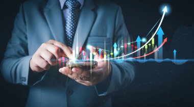 Tablet veya cep telefonu kullanan işadamı, satış verilerini ve ekonomik büyüme grafiklerini, Strateji Dijital pazarlamasını, hisse senedi gösterimini ve finans ve bankacılık kavramı için satır satır grafik grafiklerini analiz ediyor.