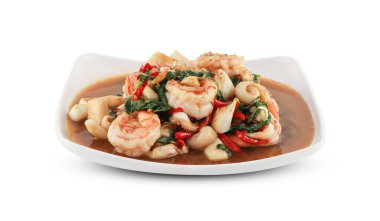 Kızarmış deniz ürünleri karidesi ve kalamar kutsal fesleğenle karıştırılır beyaz bir tabakta servis edilir kesme yolu ile izole edilmiş Tayland yemeği.