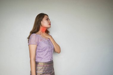 Asyalı genç bir kadın boynu ağrıdığı için boynuna dokunuyor. Boğaz ağrısı, gırtlak iltihabı, gırtlak iltihabı, yemek borusu iltihabı, tiroid iltihabı, ilotoksikoz, boğulma veya disfaji..