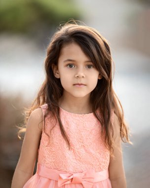 Outdoor portrtait of little girl with long hair looking at camera, childhood memories and summer holidays concept - Image
