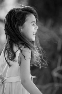 Lifestyle portrait of laughing child girl in black and white, childhood memories and summer holidays concept- Image