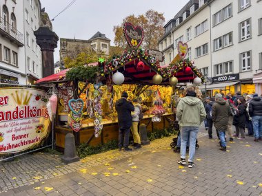 Bonn, Almanya, 12.01.2022: Mutlu insanlar alışveriş yapıyor ve Noel pazarında dolaşıyorlar.