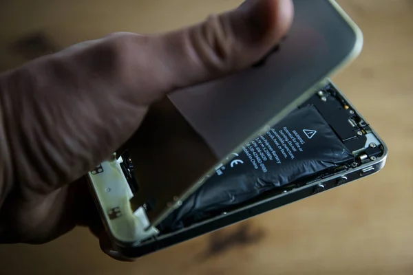 stock image Kaunas, Lithuania - 2023 Marh 13: Iphone with exploded Lithium-ion battery. Li-ion swollen battery. High quality photo