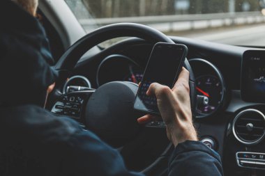 Güvenliği göz ardı eden ve araba kullanırken cep telefonu kullanan bir adam. Yüksek kalite fotoğraf