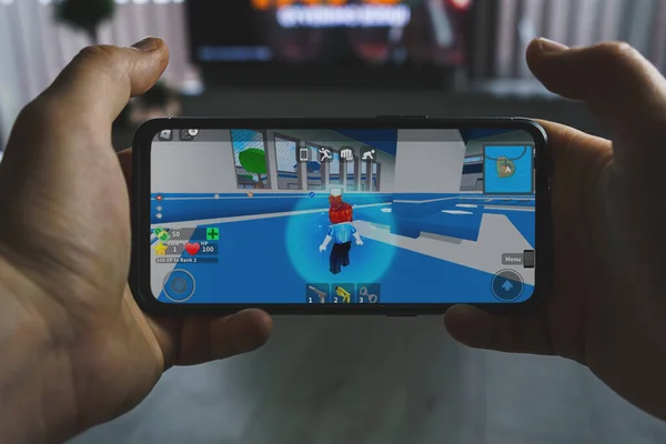 Um Smartphone Com O Logotipo Roblox Na Tela Na Pilha Dos Gamepads