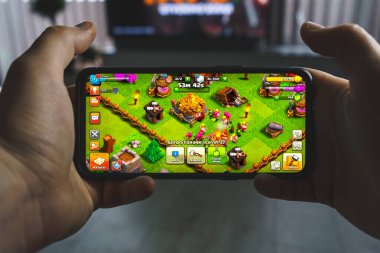 Kaunas, Lithuania - 2023 April 16: Playing Clash of clans mobile game. Point of view gaming on smartphone. High quality photo clipart
