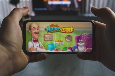 Kaunas, Litvanya - 19 Nisan 2023: Homescapes mobil oyunu oynanıyor. Bakış açısı oyunu akıllı telefondan Homescapes oyunu