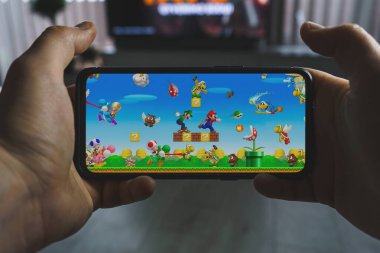 Kaunas, Litvanya - 19 Nisan 2023: Super Mario mobil oyunu oynanıyor. Bakış açısı oyunu Super Mario akıllı telefondan çalıştır