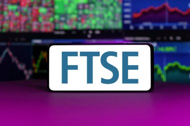 Vilnius, Litvanya - 21 Nisan 2023: FTSE 100 borsa endeksi borsa grafiklerinin önünde. Yüksek kalite fotoğraf