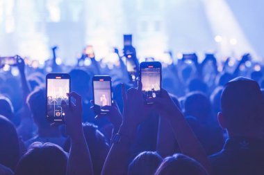 İnsanlar büyük konserde fotoğraf çekip kayıt yapıyorlar. Yakın plan çekim. Konserde akış. Yüksek kalite fotoğraf