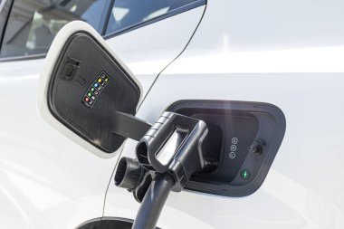 charging EV car electric vehicle clean energy for driving future. close-up shot in sunny blue sky background. High quality photo