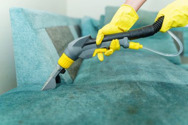 Kirli kumaş sandalyesini profesyonel bir elektrikli süpürgeyle temizleyen eldivenli profesyonel bir hademe. - Evet. Yüksek kalite fotoğraf