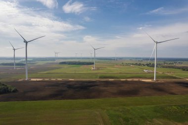 Rüzgar türbinleri yeşil tarlanın üzerinde ve mavi gökyüzü Litvanya, Avrupa 'da. Yüksek kalite fotoğraf