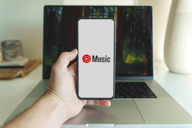 Bilgisayarın önündeki akıllı telefon ekranında Youtube müzik uygulaması logosu. Vilnius Litvanya - 2024 Kasım. Yüksek kalite fotoğraf