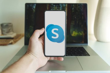 Skype uygulama logosu akıllı telefon ekranında dizüstü bilgisayarın önünde. Vilnius Litvanya - 2024 Kasım. Yüksek kalite fotoğraf