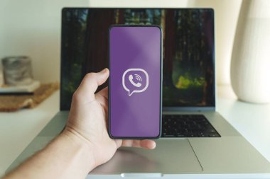 Viber mesajlaşma uygulama logosu akıllı telefon ekranında dizüstü bilgisayarın önünde. Vilnius Litvanya - 2024 Kasım. Yüksek kalite fotoğraf